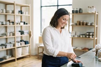 Jeune femme souriante scannant une carte de fidélité en boutique