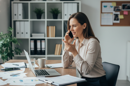 Femme en bureau moderne multitâches avec ordinateur et téléphone