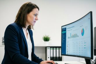 Femme responsable formation utilisant un logiciel de gestion de la formation sur ordinateur dans un bureau moderne