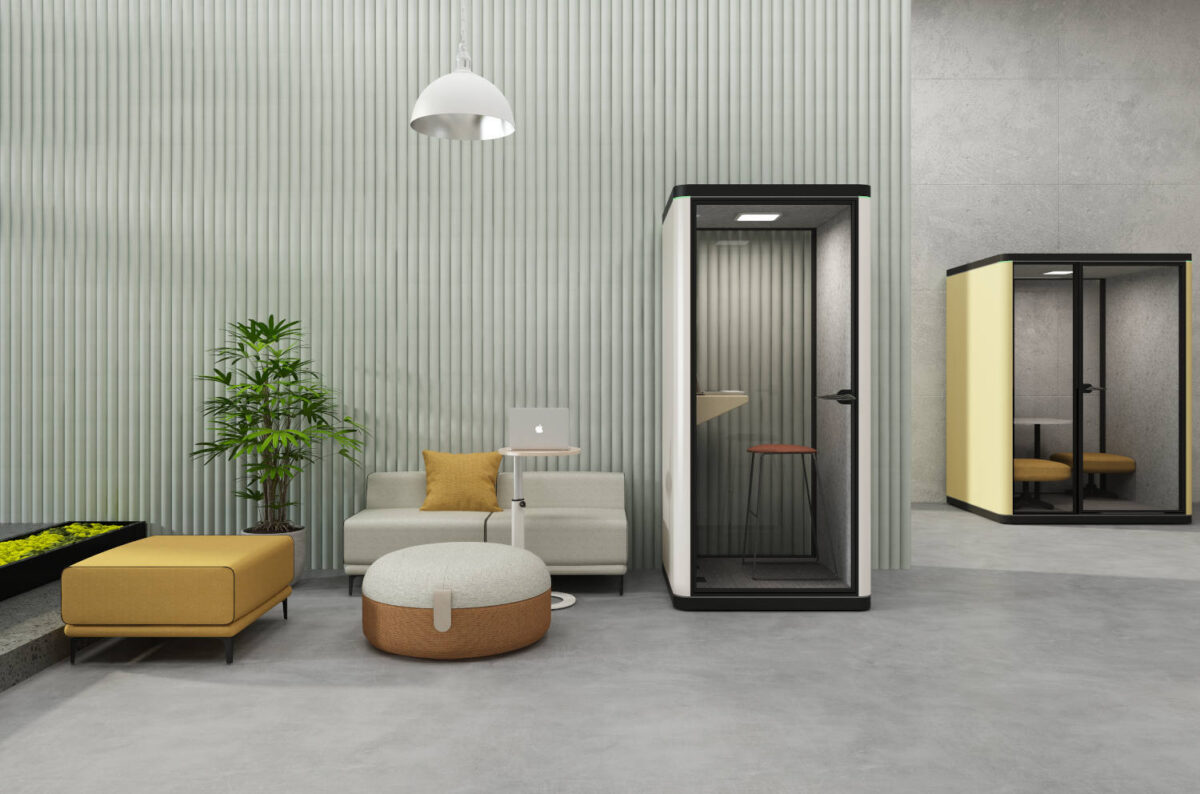 Intérieur d'une phonebox de bureau avec un homme travaillant sur un ordinateur portable