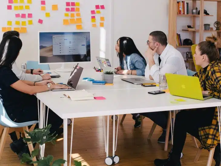 five person by table watching turned on white iMac